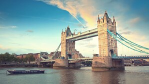 The Tower Bridge in London with a boat in the foreground. - Aparthotel Crystal Palace (London)