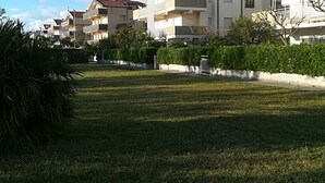 A residential area with multiple two-story buildings, each with balconies and a flat roof. - Apartment with garden overlooking the sea (Torremezzo di Falconara)