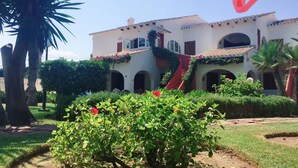 A building with a white facade, red-tiled roof, and arched windows. - Denia beach, ideal for families (Dénia)
