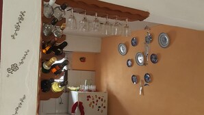 Eine Küche mit weißer Arbeitsplatte, einem Kühlschrank und einem an der Wand befestigten Tellerregal.