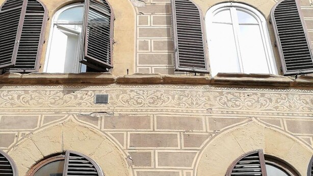 A building facade with three arched windows, each with shutters, and decorative brickwork. - Cozy and modern studio apartment by Mmega (Florence)