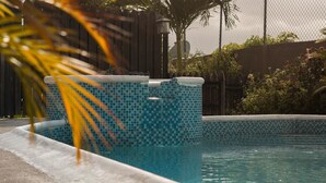 A swimming pool with a tiled edge and a concrete border. - Barri Vacation Home (Kingston)
