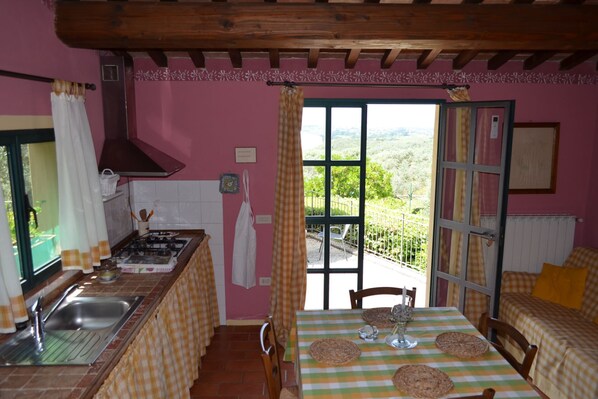 A kitchen with a gas stove, sink, and a view of the outdoors through a large window. - Situated inside olive oil farm, Altabina enjoys a panoramic position over the valley and the large h (Lamporecchio)