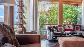 A cozy living room with a leather sofa, a wooden coffee table, and a Christmas tree.