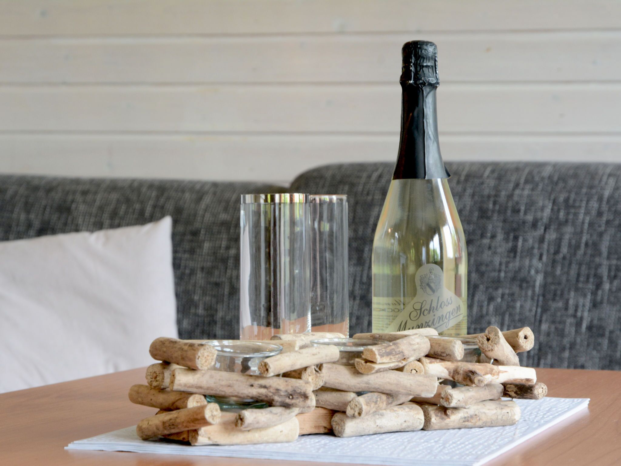 Une bouteille de vin, deux verres et une pile de bâtonnets en bois sur une table.