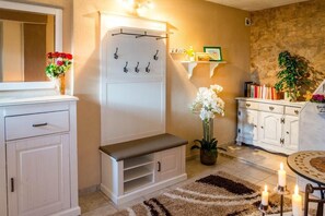 Enter a welcoming space with a bench, coat rack, and decorative shelf.