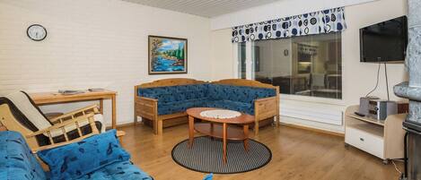 A cozy living room with a blue sofa, a wooden coffee table, and a fireplace.