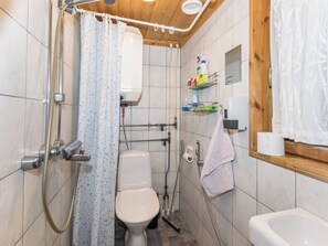 A bathroom with a shower, toilet, and sink. - Käenpesä by Interhome (Iisalmi)