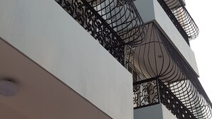 A multi-story building with balconies featuring ornate metal railings. - Hotel Quinto Nivel RD (Salcedo)
