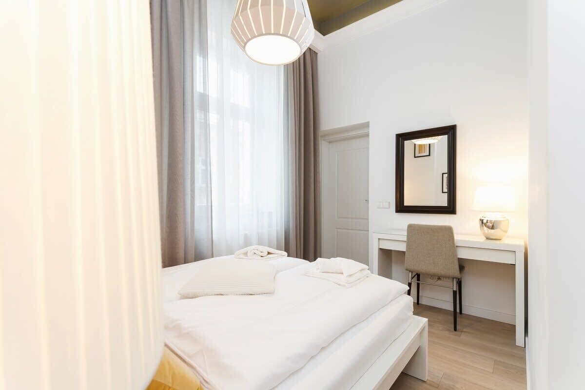 Een hotelkamer met een bed, een bureau, een stoel en een spiegel.
