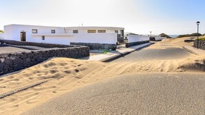 Un bâtiment moderne doté d’un toit plat, d’un mur en pierre et d’une route pavée.