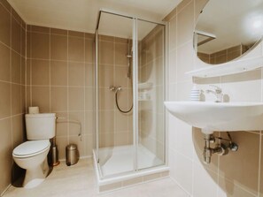 A modern bathroom with a glass-enclosed shower, a white sink, and a toilet. - The Horseshoe with parking by Interhome (Bredene)