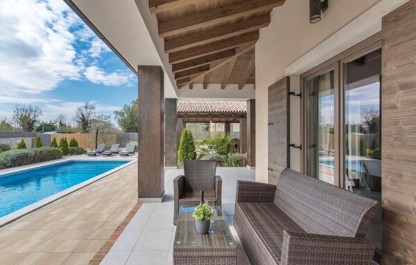 Una piscina al aire libre, sillones reclinables de piscina