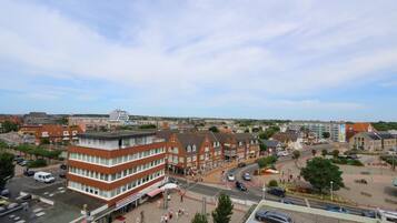 A town square with buildings, a roundabout, and a parking area.
