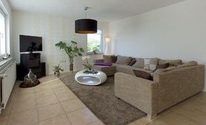 Relax in this stylish living room with a comfortable sofa set, flat-screen TV, and modern coffee table.