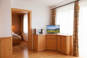 A room with a wooden cabinet, a television, and a bed. - Fuchsbau - Holiday apartment Hochnössler (Palfen)