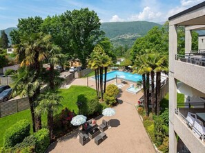 Un hôtel doté d’une piscine, d’un espace extérieur aménagé et d’une végétation luxuriante.