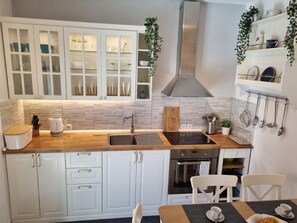 Enjoy cooking in this well-equipped kitchen with a stainless steel range hood, oven, and ample countertop space.