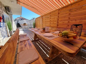 Enjoy meals al fresco at this outdoor dining area, complete with a long table and comfortable benches.