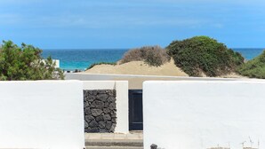 Ein Küstenhaus mit Mauerwerk, einer Tür und Blick auf das Meer.