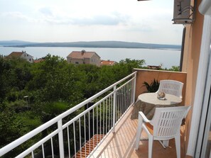 Enjoy the serene view of the water and distant hills from this balcony.