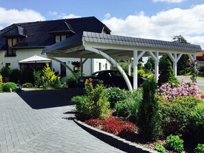 Stunning entrance with a curved roof and beautiful greenery.