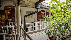 A traditional interior with a staircase, wooden chairs, and a railing. - Royal Bar & Hotel (Kandy)