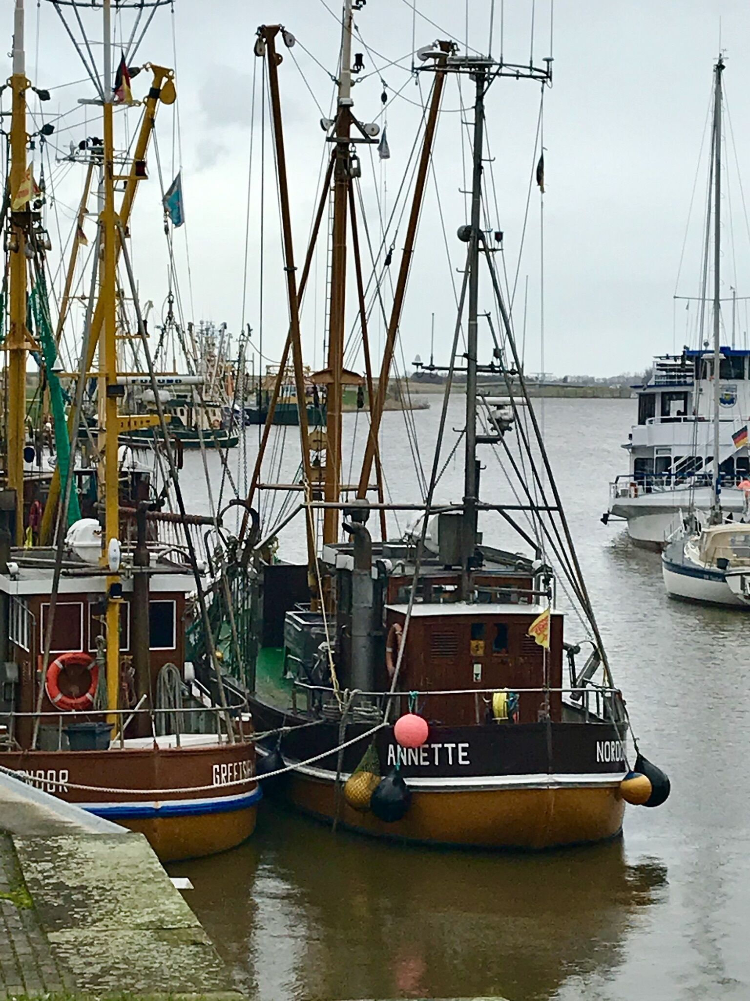 Un port où plusieurs bateaux sont amarrés, dont un bateau remarquable appelé « ANNETTE ».