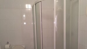 A bathroom with a toilet, a shower enclosure, and a sink. - Hostel&Guesthouse Sim Sim (Samarkand)