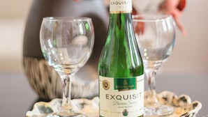 A bottle of Exquisit beer on a table with two empty glasses. - Apartment Elbflorenz (Dresden)