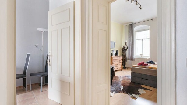 A room with a bed, dresser, and a chair. - Apartment Elbflorenz (Dresden)