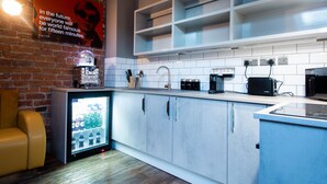 A modern kitchen with a brick wall, a refrigerator, and a coffee machine. - York Street Studios (Liverpool)