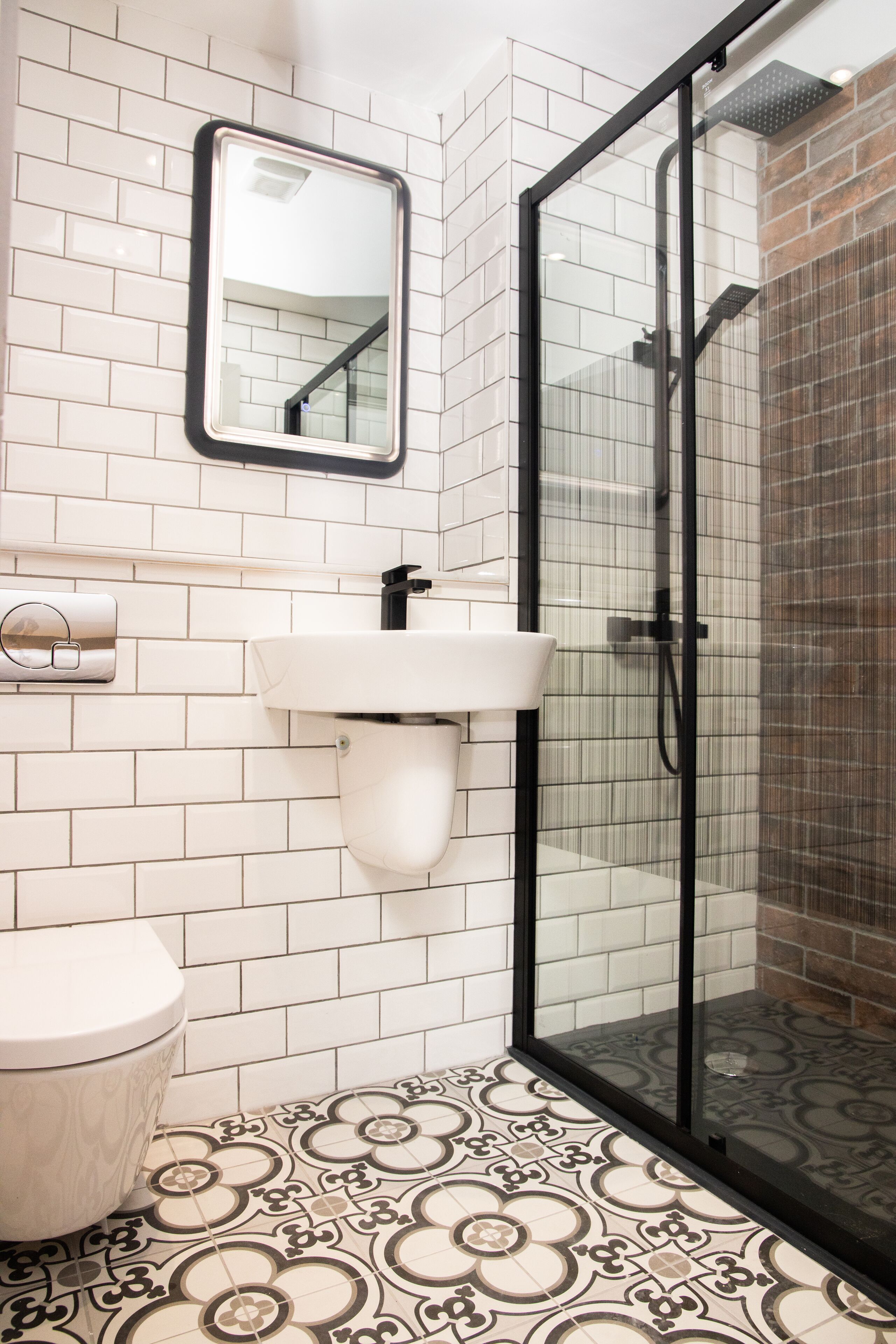 A bathroom with a white toilet, a sink with a mirror above it, and a shower with a glass door.