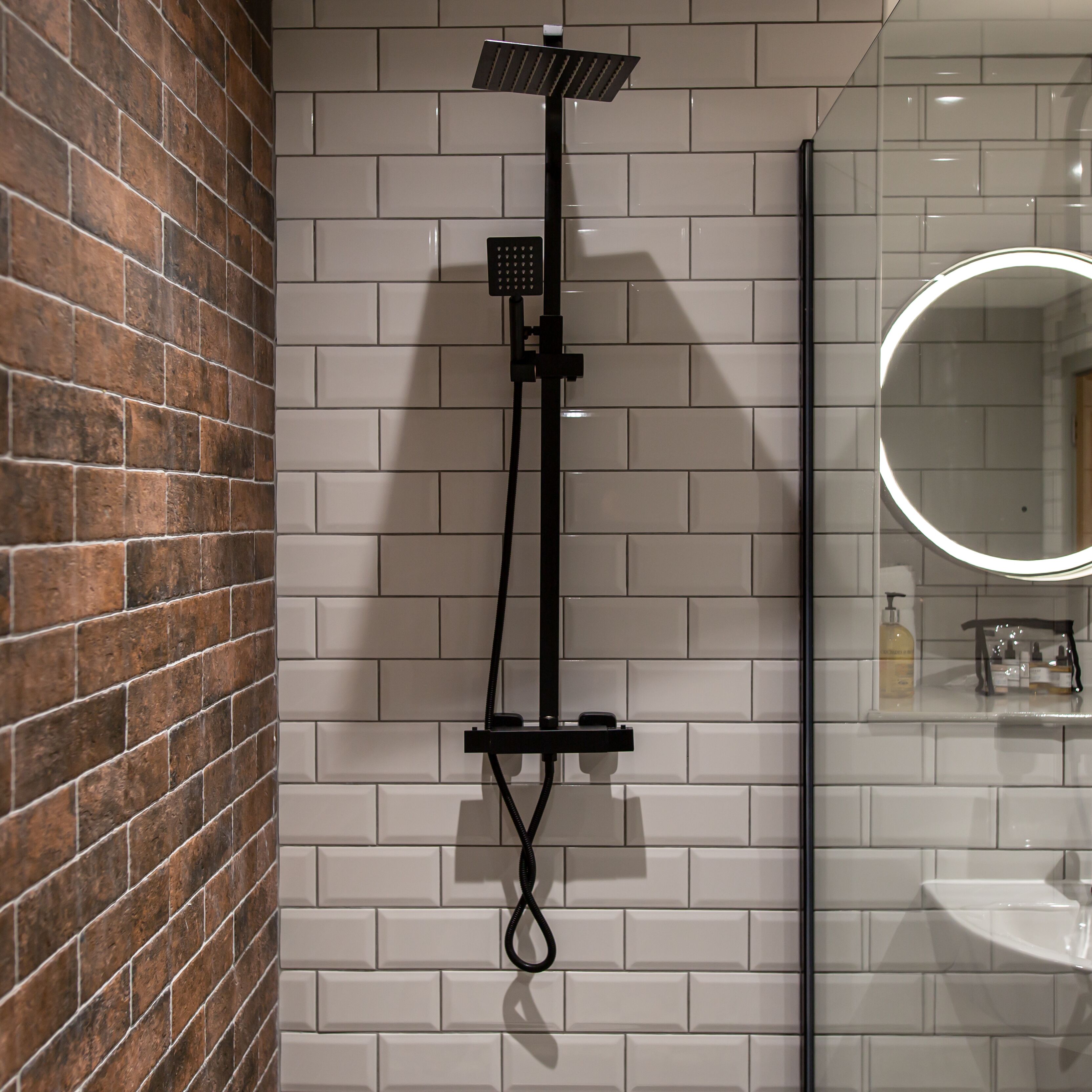 A bathroom with a shower, a sink, and a mirror.
