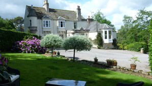 A large, two-story house with a driveway and a well-maintained lawn. - Craigellachie Lodge (Aberlour)