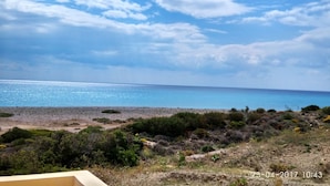 A coastal landscape with a beach, vegetation, and a clear sky. - Holiday House Myrtos (Rhodes)