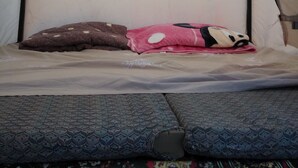 A tent with a bed inside, featuring a mattress, pillows, and a canopy. - Al sultan bedouin camp (Wadi Rum)