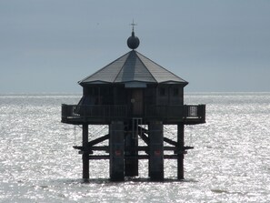 Una estructura de faro sobre pilotes, sobre el agua.
