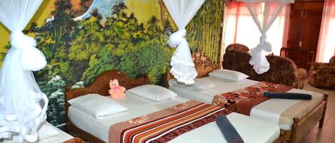 Habitación de hotel con dos camas, cada una con corredor de dosel y colcha de motivos florales.