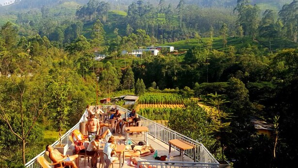 A terrace with outdoor seating and a view of lush green hills and tea plantations. - Grand Adams Peak Hotel (Nallathanniya)