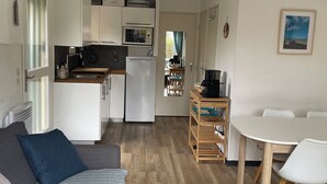 Un espai vital compacte amb petita cuina, menjador i sofà.