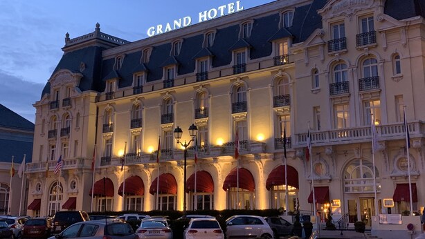 Un hotel gran d'estil arquitectònic europeu clàssic, amb finestres apuntades i una entrada destacada.