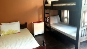 Camera con letto a castello, un letto singolo e un comodino bianco.