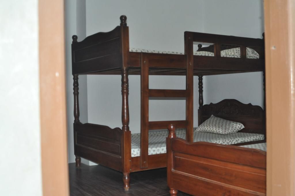 A bunk bed with a ladder, a wooden headboard, and patterned bedding.