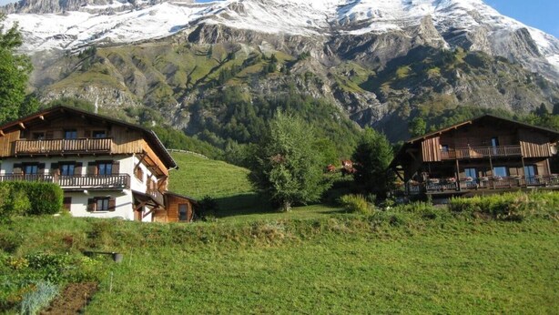 Panorama montuoso con edifici in stile chalet in primo piano.