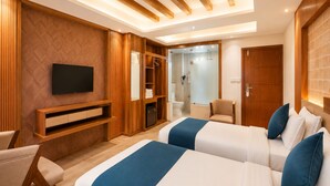 Habitación de hotel con techo de madera, televisor, armario, ducha y dos camas.