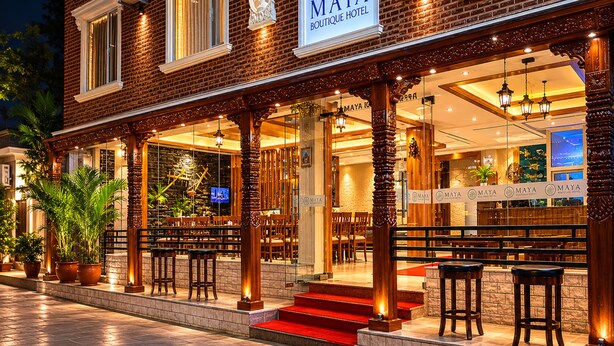 Un edificio de ladrillo con un letrero que dice 'MAYA Boutique Hotel'.