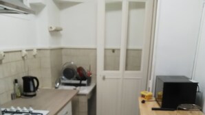 Cocina compacta con estufa a gas, cafetera y microondas.
