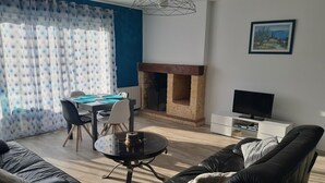 Una sala de estar moderna con chimenea, comedor y televisor.