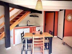 Eine kleine Küche mit Essbereich, einer Waschmaschine und einer Treppe.